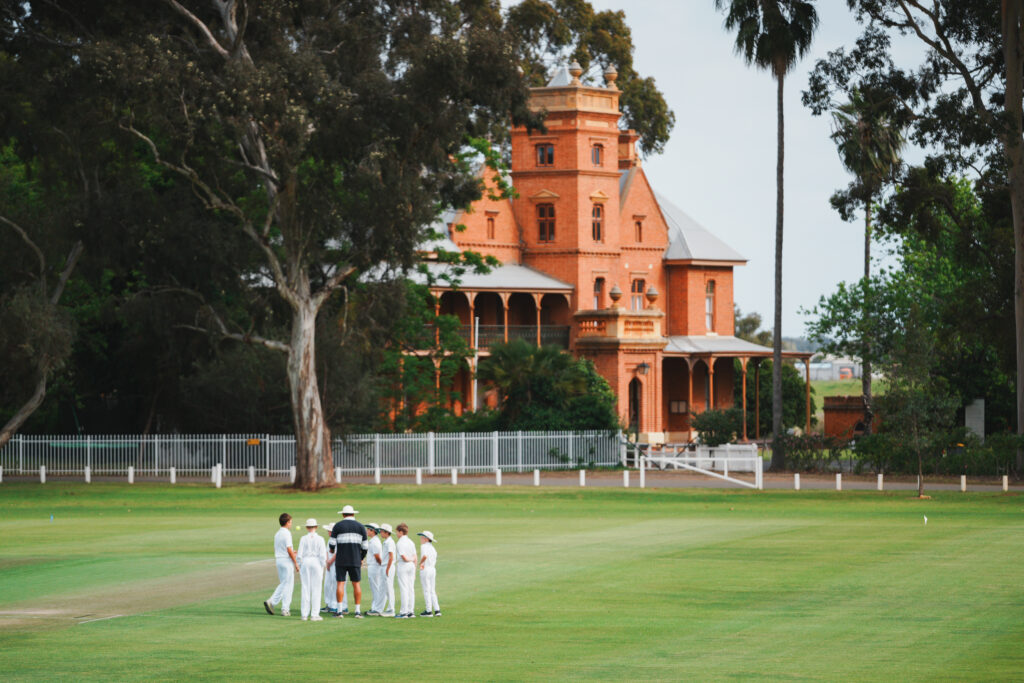 Cricket team gathering on the oval at Guildford Grammar School, Western Australia.
