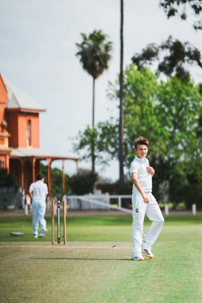 Young cricketer bowler on the oval at Guildford Grammar School - sport celebration.